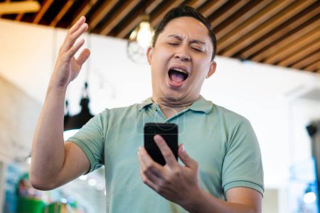 Homme adulte en colère et choqué par quelque chose sur son téléphone