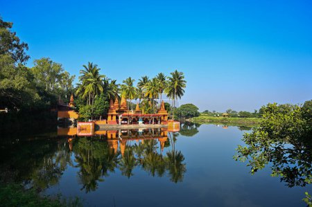 Photo for Temple on the lake. Hindu Temple. Palm trees and lake. Blue Sky. Lovely Water reflection. Maharashta. india - Royalty Free Image