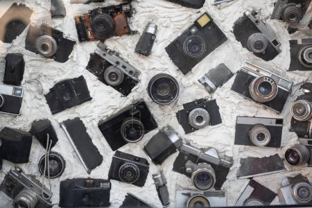 Photo for Photographic equipment Immured in concrete view from above. Composition of retro cameras and lenses. Old vintage camers. - Royalty Free Image