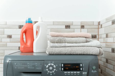 Téléchargez les photos : Machine à laver nettoyer les serviettes et les bouteilles avec des produits chimiques ménagers pour le lavage. Laver les serviettes éponge - en image libre de droit
