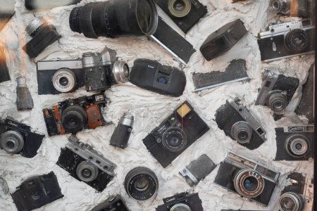 Photo for KHARKIV, UKRAINE - 07 OCTOBER 2018: Old retro cameras and lenses Immured in concrete. Vintage photographic equipment. - Royalty Free Image