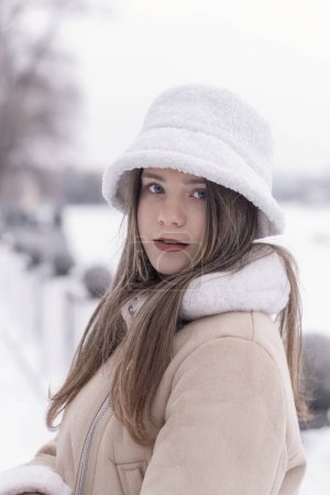 Foto de Retrato de niña seria en panama de piel blanca afuera en invierno. Ropa de mujer caliente de moda. - Imagen libre de derechos