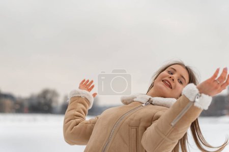 Foto de Hermosa chica recta su pelo largo disfruta de la naturaleza de invierno. Ropa de mujer cálida, día de invierno. - Imagen libre de derechos