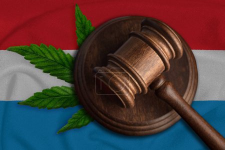 Téléchargez les photos : Gavel en bois Justice avec feuille de cannabis sur le drapeau du Luxembourg. Croissance illégale de plantes de cannabis et propagation de drogues. - en image libre de droit