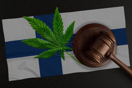 Téléchargez les photos : Drapeau de la Finlande et justice marteau en bois avec feuille de cannabis. Croissance illégale de plantes de cannabis et propagation de drogues - en image libre de droit