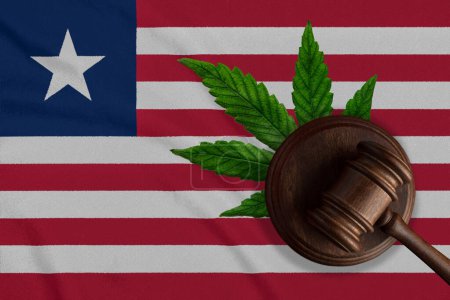 Téléchargez les photos : Gavel en bois Justice avec feuille de cannabis sur le drapeau du Libéria. Croissance illégale de plantes de cannabis et propagation de drogues. - en image libre de droit
