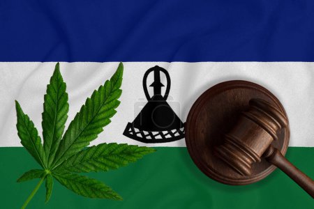 Téléchargez les photos : Gavel en bois Justice avec feuille de cannabis sur le drapeau du Lesotho. Croissance illégale de plantes de cannabis et propagation de drogues. - en image libre de droit