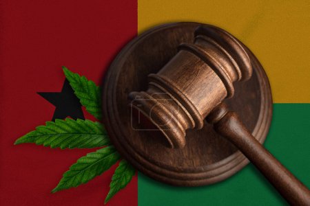 Bandera de Guinea Bissau y mazo de madera de justicia con hoja de cannabis. Crecimiento ilegal de plantas de cannabis y la propagación de drogas