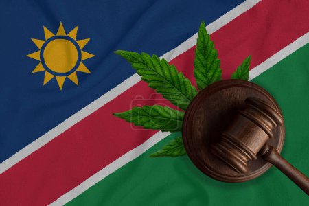 Téléchargez les photos : Goujon en bois judiciaire, feuille de chanvre frais et drapeau de Namibie. Vente et distribution illégales de marijuana. - en image libre de droit