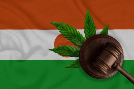 Téléchargez les photos : Un marteau sur le fond du drapeau du Niger avec l'image d'une feuille de cannabis et le drapeau du pays. Le concept de légalisation de la marijuana dans le pays. - en image libre de droit