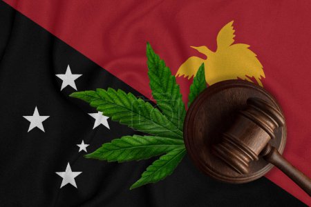 Téléchargez les photos : Gavel et feuille de chanvre sur le fond du drapeau de Papouasie-Nouvelle-Guinée. Le concept de légalisation de la marijuana en Papouasie-Nouvelle-Guinée. - en image libre de droit