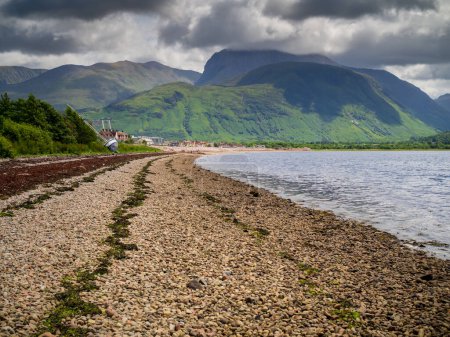 Photo for The view along the waterfront at Corpach, taking in the Corpach Wreck leading across the the foothills and bulk of Ben Nevis with its peak hidden in cloud - Royalty Free Image