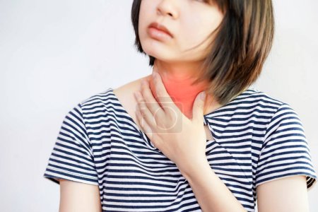 Foto de Una mujer tiene dolor de garganta y enrojecimiento o hinchazón en la garganta. - Imagen libre de derechos