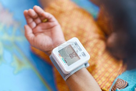 Photo for Self-measurement of blood pressure using a device on the wrist of the elderly. - Royalty Free Image