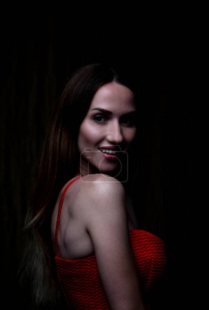 Photo for Mysterious allure and captivating gaze of a young woman in a striking studio portrait. - Royalty Free Image