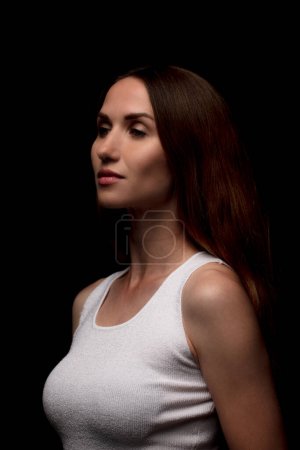 Téléchargez les photos : Femme avec maquillage naturel portant un haut blanc sur fond marron - en image libre de droit