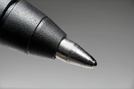 Téléchargez les photos : Détail vue partielle extrême gros plan de la pointe du stylo roller comme concept pour l'écriture de signature et l'écriture sur fond gris - en image libre de droit