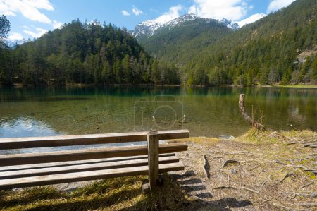 Téléchargez les photos : Banc en bois dans Paysage à paysage de montagne idyllique lac en Autriche Tyrol relax montagnes partiellement enneigées vert clair eau ciel bleu partiellement nuageux concept de relaxation - en image libre de droit
