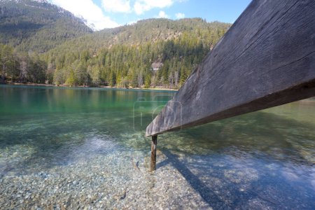 Téléchargez les photos : Plan grand angle d'un lac de montagne clair intact au Tyrol avec clôture menant à l'eau invitation à nager dans la nature intacte et concept pour le temps des vacances de tourisme et de vacances - en image libre de droit