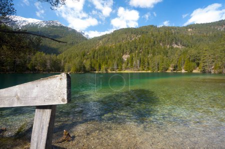 Téléchargez les photos : Intact Naru au lac de montagne vierge au Tyrol paysage tourné clôture en bois ciel bleu forêts partiellement nuageuses et sommets enneigés comme concept pour la détente en pleine nature calme et silence - en image libre de droit