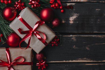 Foto de Vista superior foto Navidad flatlay cajas de regalo, juguetes de árbol de Navidad rojo y brance de abeto sobre fondo de madera. Fondo de Navidad con espacio para text.Copyspace. - Imagen libre de derechos