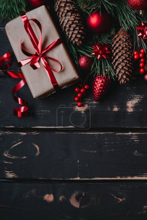 Foto de Vista superior foto Christmass flatlay caja de regalo, juguetes de árbol de Navidad rojo y brance de abeto sobre fondo de madera. Fondo de Navidad con espacio para text.Copyspace.Foto vertical. - Imagen libre de derechos