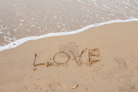 Photo for Love lettering on the sandy beach and sea water. - Royalty Free Image