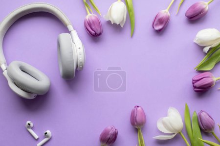 Téléchargez les photos : Casque sans fil et tulipes de printemps sur fond violet.Vue de dessus photo.Espace de copie. - en image libre de droit
