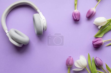 Téléchargez les photos : Wireless headphones and Spring tulips on violet background.Top view photo.Copy space. - en image libre de droit