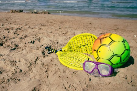 Foto de Raqueta de tenis de playa y pelota de color amarillo, máscara de natación y pelota de voleibol de playa en la playa tne. Copiar el espacio.. - Imagen libre de derechos
