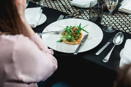 Téléchargez les photos : Woman in a restaurant going to eat spicy shrimp tacos with coleslaw and salsa. Black tablecloth - en image libre de droit