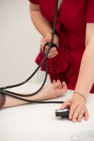 Médico revisando la presión arterial del paciente. Asistencia sanitaria.