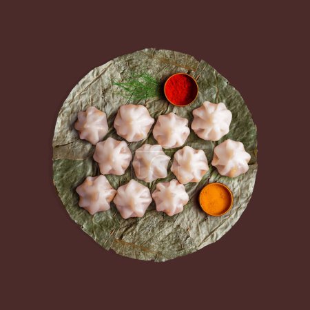 Téléchargez les photos : Patravali, Pattal, Vistaraku, Vistar ou Khali est une assiette à manger indienne ou trancheuse faite avec de larges feuilles séchées. Il est principalement fabriqué à partir de feuilles de sal. Assiette ou plat écologique. avec doux Modak Laddu - en image libre de droit