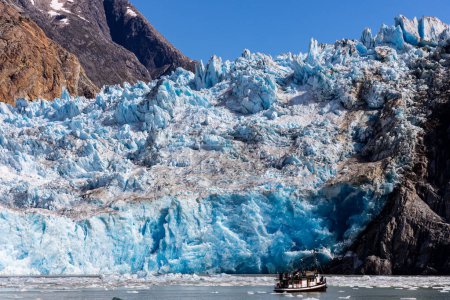 Téléchargez les photos : Un bateau est dominé par le glacier South Sawyer près de Juneau, en Alaska, situé dans le fjord Tracy Arm. - en image libre de droit