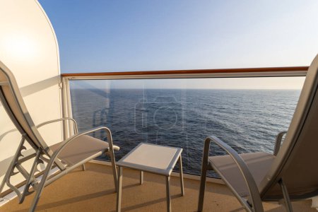 Crucero barco balcón con dos sillas y mesa.