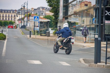 Photo for Dordogne, France July 02 2023: Young Rider on a 125cc Motorcycle in Urban Area - Royalty Free Image