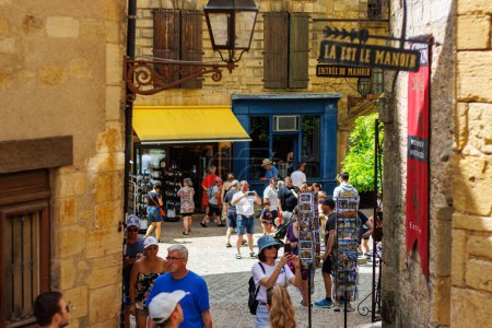 Foto de Sarlat, Francia Agosto 07 2023: En medio de callejones atemporales: turistas explorando las calles históricas de Sarlat. - Imagen libre de derechos