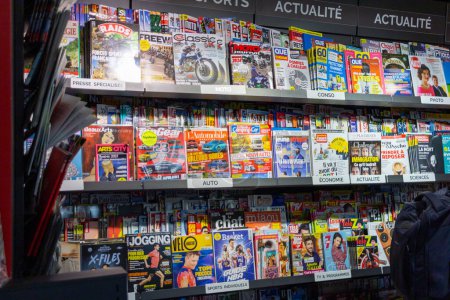 Foto de Perigueux, Francia Octubre 23, 2023: Diverse Magazine Rack en una tienda minorista - Imagen libre de derechos