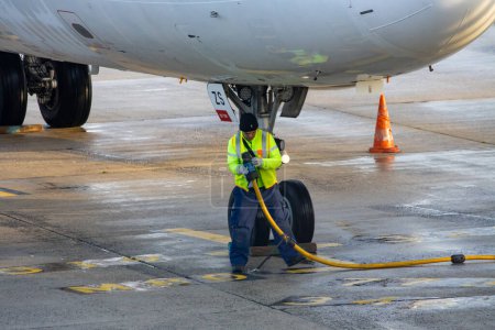 Foto de Aeroport Charles de Gaulle, Francia Octubre 24, 2023: Empleado de aeropuertos asegura repostaje seguro de aviones - Imagen libre de derechos