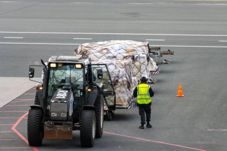 Téléchargez les photos : Aéroport Helsinki-Vantaa, Finlande, 24 octobre 2023 : Tracteur avec remorque sur le tarmac de l'aéroport - en image libre de droit