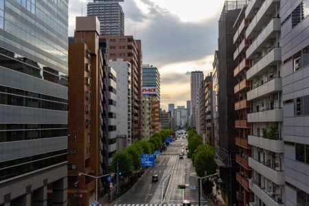 Photo for Tokyo, Japan, October 25, 2023: Urban Road Flanked by Modern Buildings at Dusk - Royalty Free Image