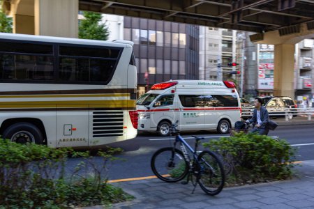 Téléchargez les photos : Tokyo, Japon, 26 Octobre 2023 : Ambulance et vie de banlieue sous le pont de la ville - en image libre de droit