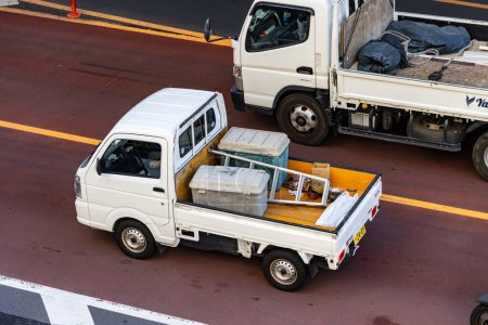Foto de Tokio, Japón, 26 de octubre de 2023: Camiones compactos en carretera urbana - Imagen libre de derechos