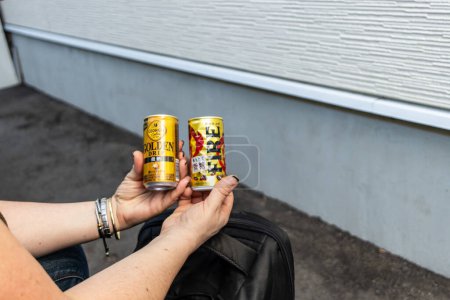 Téléchargez les photos : Tokyo, Japon, 26 Octobre 2023 : Personne tenant deux boissons en conserve à l'extérieur - en image libre de droit