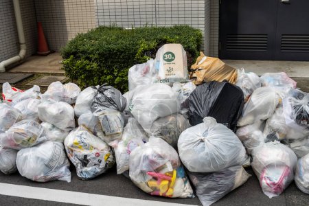 Téléchargez les photos : Tokyo, Japon, 28 octobre 2023 : Sacs à ordures empilés dans une rue de Tokyo pour collecte - en image libre de droit