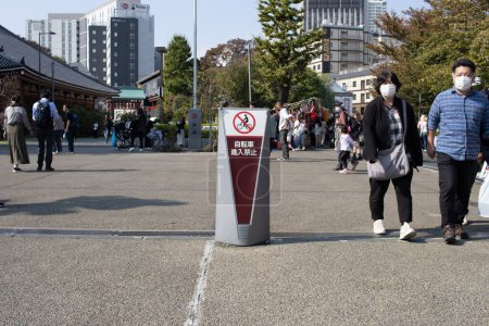 Photo for Tokyo, Japan, 28 October 2023 : Pedestrians Passing a No Smoking Sign in Asakusa - Royalty Free Image