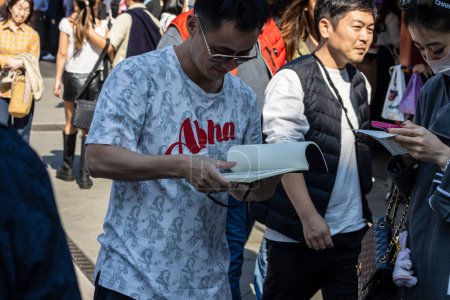 Téléchargez les photos : Tokyo, Japon, 28 octobre 2023 : Un homme écrit des notes dans une rue animée d'Asakusa - en image libre de droit