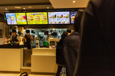 Téléchargez les photos : Tokyo, Japon, 29 Octobre 2023 : Comptoir de commande dans un fast-food avec menus numériques - en image libre de droit