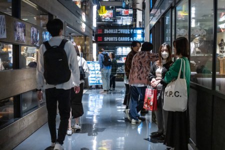 Téléchargez les photos : Tokyo, Japon, 29 Octobre 2023 : Collectionneurs parcourant les cartes de sport dans un magasin spécialisé - en image libre de droit