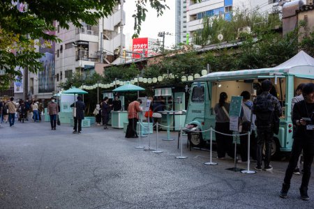 Téléchargez les photos : Tokyo, Japon, 29 octobre 2023 : Des gens font la queue dans des camions-restaurants dans une rue urbaine - en image libre de droit